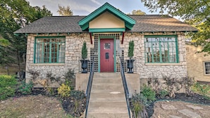 A stone house with a red door, green window frames, and a small porch with black railings. - 2 Mi to Hot Springs Nat'l Park: Hot Tub Haven! (Hot Springs)