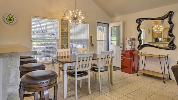 A kitchen with a dining area, including a wooden table, white chairs, and a bar stool. - Pet-friendly Home w/ Deck: 1 Mi to Canyon Lake Fun (Canyon Lake)