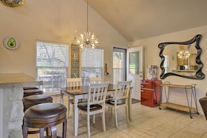 A kitchen with a dining area, including a wooden table, white chairs, and a bar stool. - Pet-friendly Home w/ Deck: 1 Mi to Canyon Lake Fun (Canyon Lake)