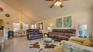 A spacious living room with leather sofas, a glass coffee table, and a dining area with a table and chairs. - Pet-friendly Home w/ Deck: 1 Mi to Canyon Lake Fun (Canyon Lake)