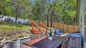 An outdoor patio with a wooden table and chairs, a small garden area, and a wooden fence. - Pet-friendly Home w/ Deck: 1 Mi to Canyon Lake Fun (Canyon Lake)