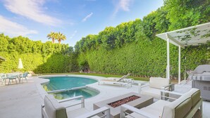 An outdoor pool area with a curved pool, lounge chairs, and a barbecue grill. - 1 Mi to Dtwn Palm Springs: Home w/ Fire Pit! (Palm Springs)