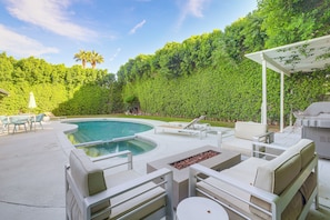 An outdoor pool area with a curved pool, lounge chairs, and a barbecue grill. - 1 Mi to Dtwn Palm Springs: Home w/ Fire Pit! (Palm Springs)