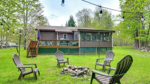 A lodge with a deck, outdoor seating, and a fire pit. - Peaceful Wooded Retreat at Lake Wallenpaupack! (Lake Ariel)