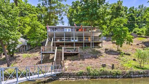 A multi-level cabin with a dock and a staircase leading to the upper deck. - Waterfront Home w/ 3 Decks on Lake of the Ozarks! (Sunrise Beach)