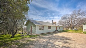 A single-story house with a sloped roof, a chimney, and a front porch. - Authentic Escape at the Exact Center of CA! (North Fork)