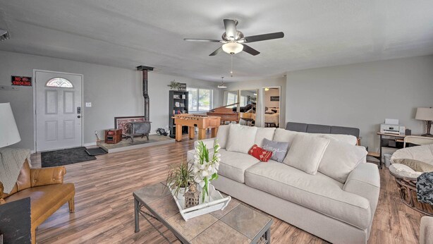 A living room with a sofa, coffee table, and a ceiling fan. There is a door with a 'No Smoking' sign, a piano, and a bookshelf. - Authentic Escape at the Exact Center of CA! (North Fork)