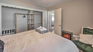 A bedroom with a large bed, a heater, and a wardrobe. - Authentic Escape at the Exact Center of CA! (North Fork)