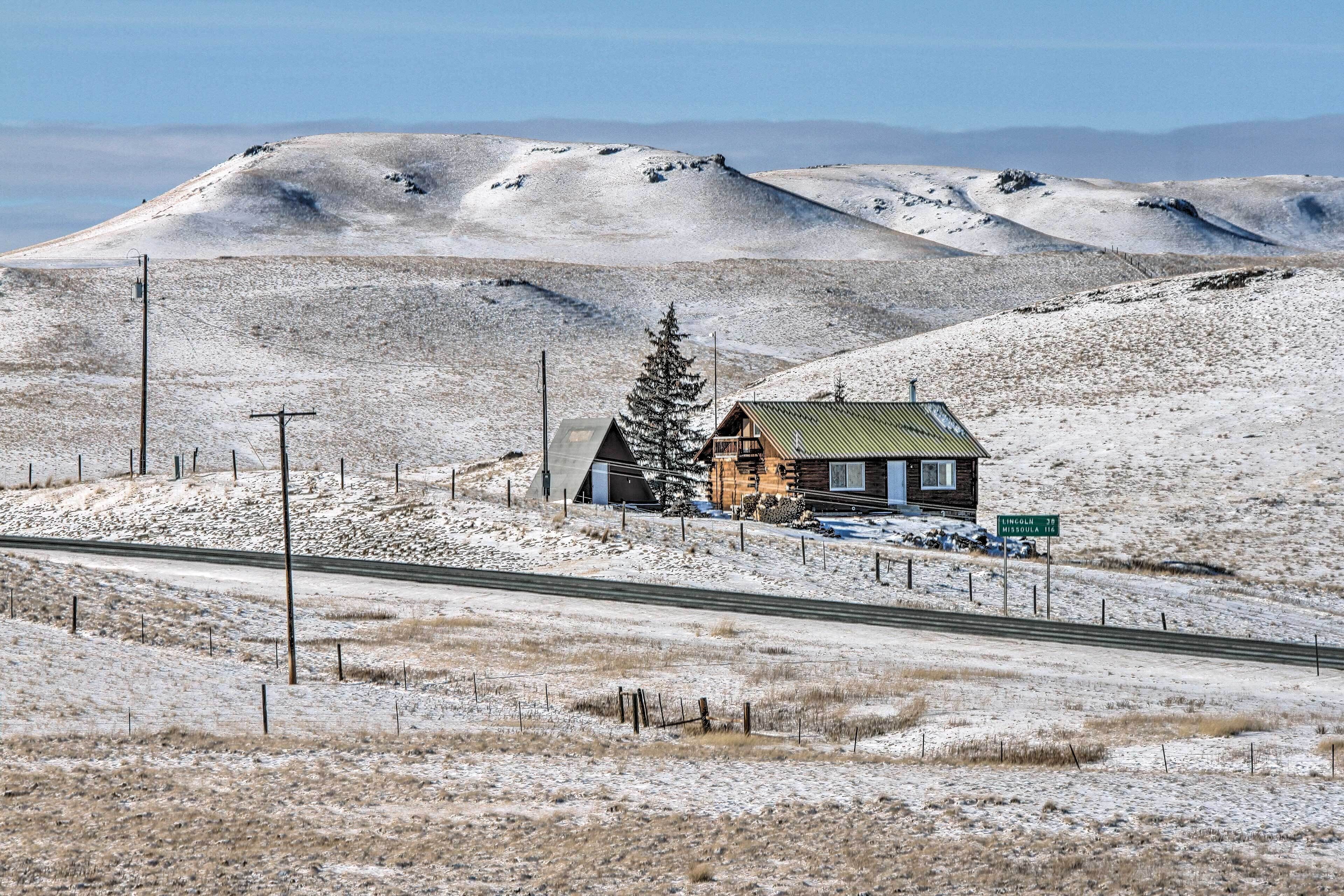 Schneebedeckte Landschaft mit einer Holzhütte und einer Straße.