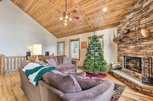 A cozy living room with a fireplace, a Christmas tree, and a comfortable couch.