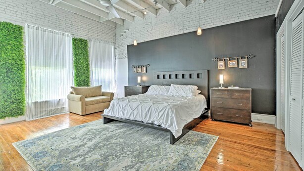 A bedroom with a bed, a dresser, and a chair. - Walk to Dtwn Distilleries: Nulu Art District Loft (Louisville)