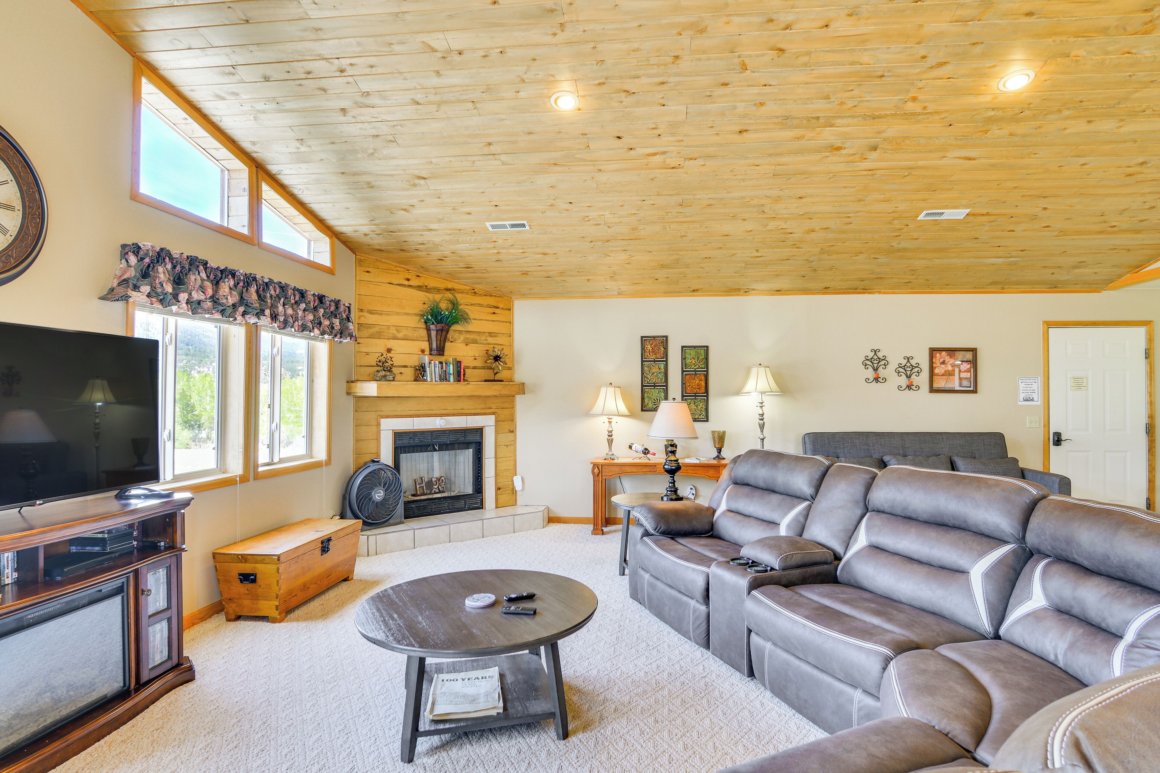 A living room with a fireplace, leather sofa, and a television.