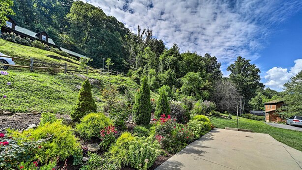 A landscaped garden with various plants and a paved walkway. - Striking Waynesville Home w/ Mtn Views & Deck (Waynesville)