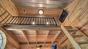 A wooden interior with a balcony, a circular light fixture, and a ventilation system. - Riverfront Cottage: Fire Pit & Kayaks (Deltaville)