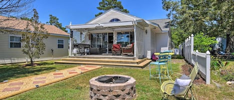 A house with a covered porch, a fire pit, and outdoor furniture.