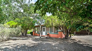 A house with a gravel driveway, surrounded by trees and shrubs.