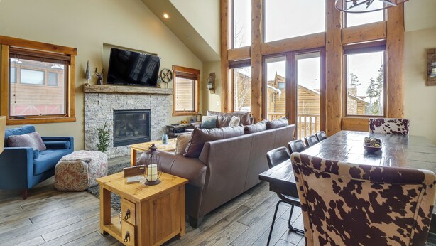 A spacious living room with a fireplace, large windows, a television, and a dining area with a table and chairs. - Colorado Lodge w/ Mtn Views - 3 Mi to Winter Park! (Winter Park)