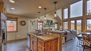A spacious kitchen with wooden cabinets, a large island, and pendant lighting. - Colorado Lodge w/ Mtn Views - 3 Mi to Winter Park! (Winter Park)
