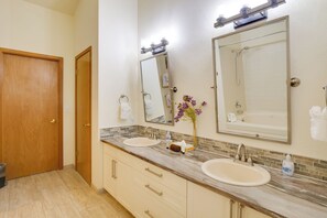 A bathroom with two sinks, a shower, and a wooden door. - Homey Dog-friendly Retreat w/ Deck in Dtwn Frisco! (Frisco)