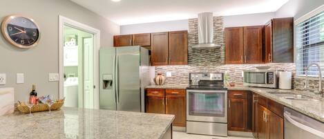 A modern kitchen with granite countertops, stainless steel appliances, and wooden cabinets.