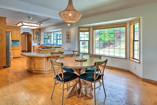 A spacious kitchen with wooden cabinets, a central island, and a dining area with chairs.