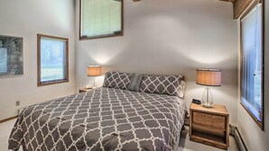 A bedroom with a large bed, two bedside lamps, and a nightstand with a lamp. - Colorado Home On Golf Course, Near Vail Ski Resort (Avon)