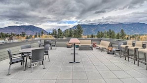 A rooftop patio with outdoor seating, a table, and a lamp. - Sleek Columbia Falls Condo: Centrally Located! (Columbia Falls)
