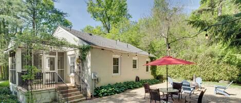 A house with a covered patio, outdoor seating, and a gravel driveway.