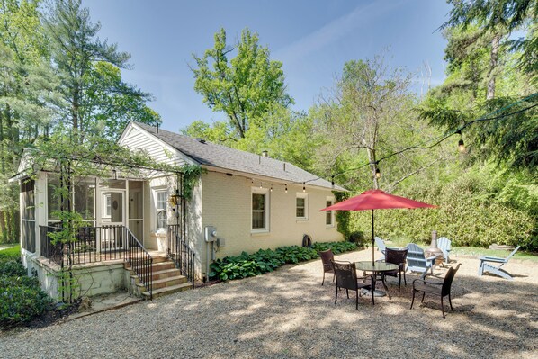 Une maison dotée d’un patio couvert, d’un espace salon extérieur et d’une allée en gravier.
