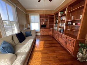 Cozy living room with a sofa, bookshelf, and flat-screen TV.