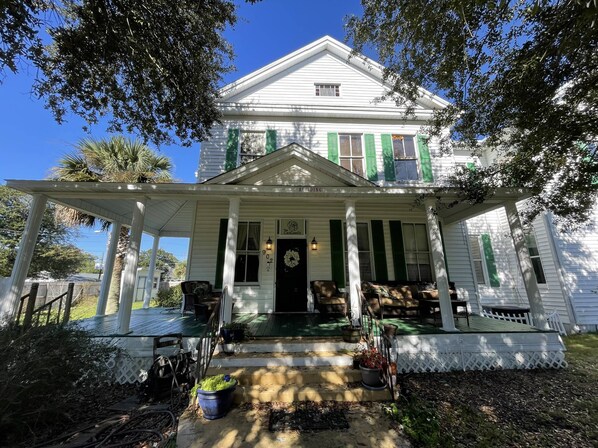 Stroll up to the charming entrance, where a welcoming porch awaits with a small set of steps and potted plants.