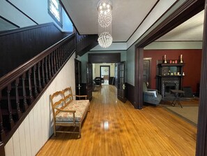 Step into this elegantly designed space, featuring a grand staircase, traditional fireplace, and cozy seating area.