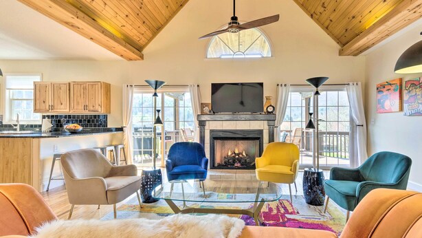 A spacious living room with a fireplace, a television, and a variety of seating options including a fur throw and multiple chairs. - Asheville Retreat w/ Game Room & Mountain Views! (Asheville)