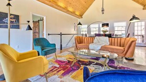 A spacious living area with a high ceiling, a glass coffee table, and modern furniture. - Asheville Retreat w/ Game Room & Mountain Views! (Asheville)