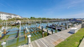 A marina with wooden docks and boats, surrounded by greenery and buildings. - Boat Slip & Pool Access: Ocean City Home! (Ocean City)