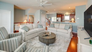 A modern living room with a sectional sofa, a round coffee table, and a flat-screen TV. - Boat Slip & Pool Access: Ocean City Home! (Ocean City)