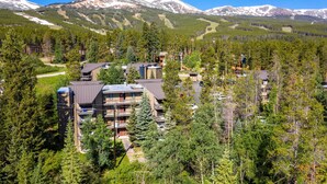 A mountain lodge with multiple buildings surrounded by dense forest and snow-capped mountains in the background. - < 1 Mi to Peak 8: Ski Condo in Breck w/ Mtn Views (Breckenridge)