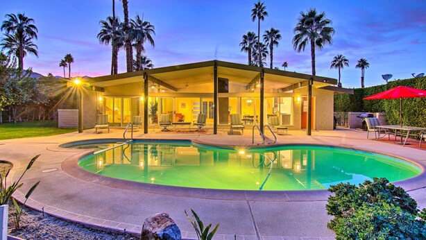 A modern house with a swimming pool, surrounded by palm trees and a well-lit patio area. - Palm Springs Oasis w/ Pool & Golf Course Views! (Palm Springs)