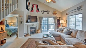 A spacious living room with a fireplace, a large sofa, and a television. - Steamboat Springs Condo w/ Hot Tub & Ski Bus! (Steamboat Springs)