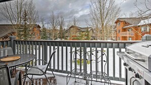 A covered outdoor patio with a grill, chairs, and a table. - Steamboat Springs Condo w/ Hot Tub & Ski Bus! (Steamboat Springs)
