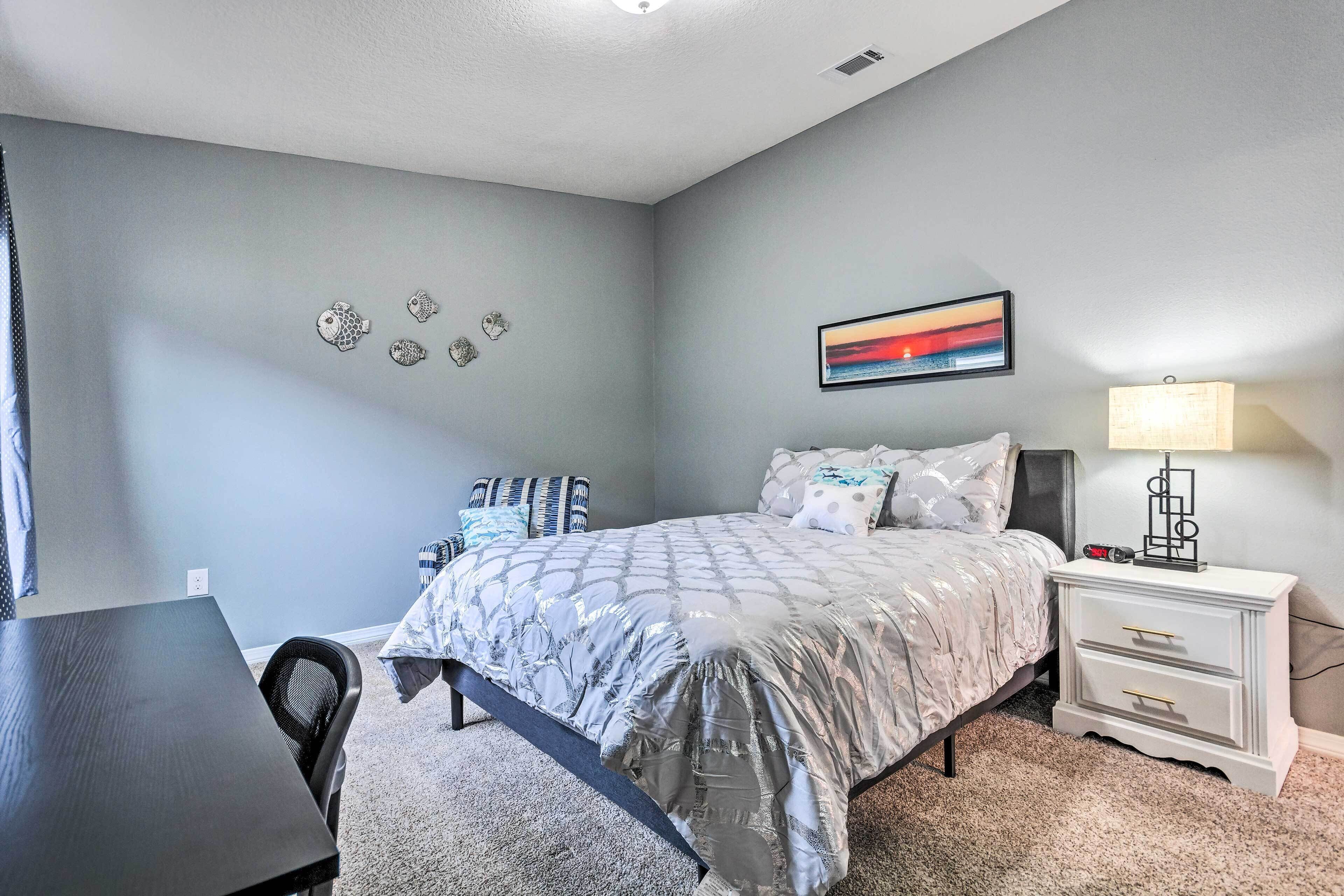 Une chambre à coucher avec un lit, une table de chevet, une lampe et des éléments décoratifs sur les murs.
