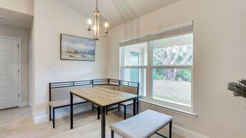 A dining area with a wooden table, benches, and a bench seat.