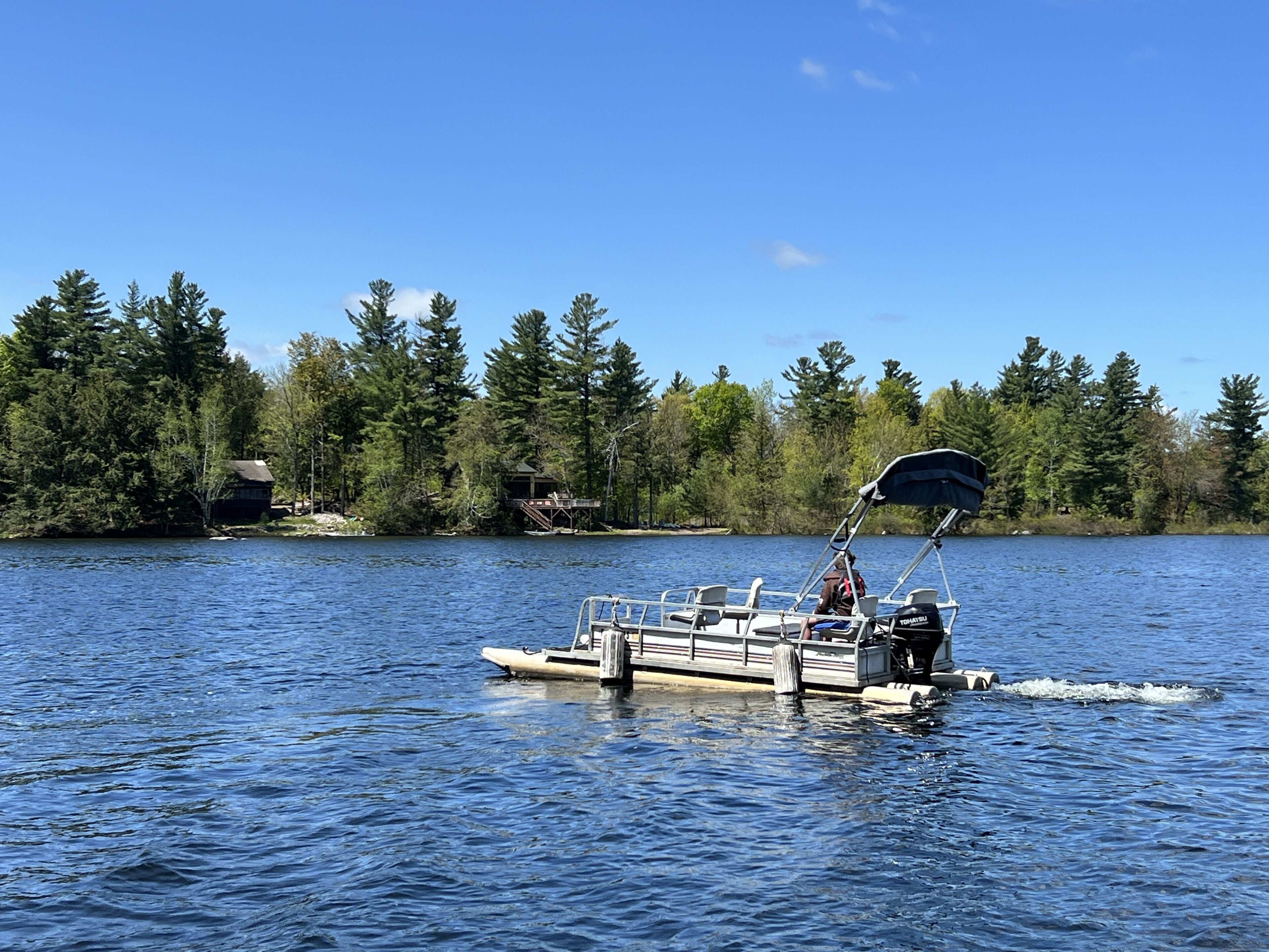 A boat on a lake with a forested shore.