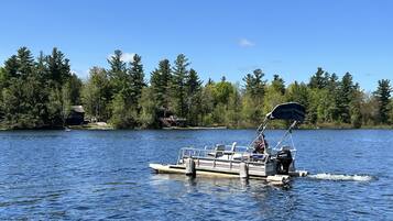 A boat on a lake with a forested shore.