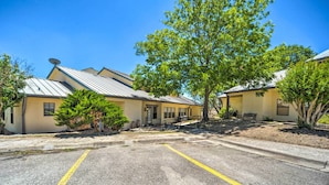 A row of single-story buildings with a parking lot in front. - Kerrville Retreat on 18th Hole of Riverhill! (Kerrville)