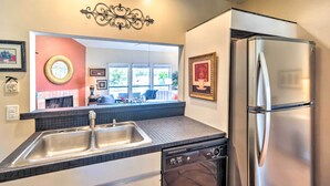 A kitchen with a double sink, stainless steel refrigerator, and a dishwasher. - Kerrville Retreat on 18th Hole of Riverhill! (Kerrville)
