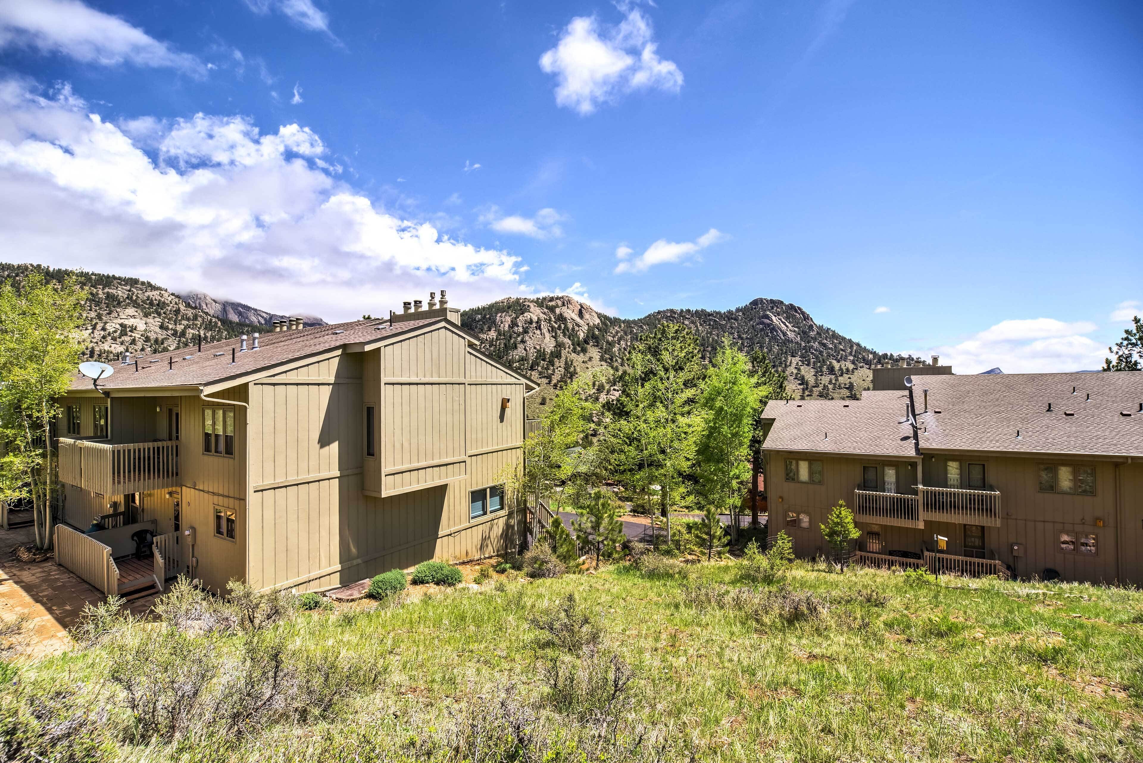 A two-story building with a balcony, surrounded by natural landscape and mountains.