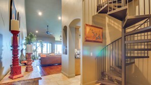 A spacious interior with a staircase, a dining area, and a kitchen visible in the background. - Top-floor Lake-view Condo w/ Boat Dock Access (Lakeway)