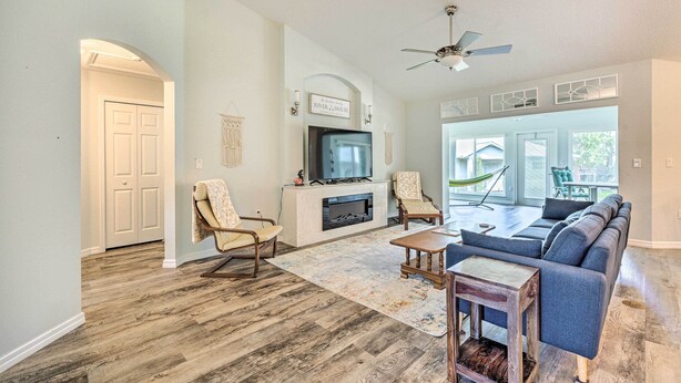A living room with a fireplace, seating area, and a view to the outside.