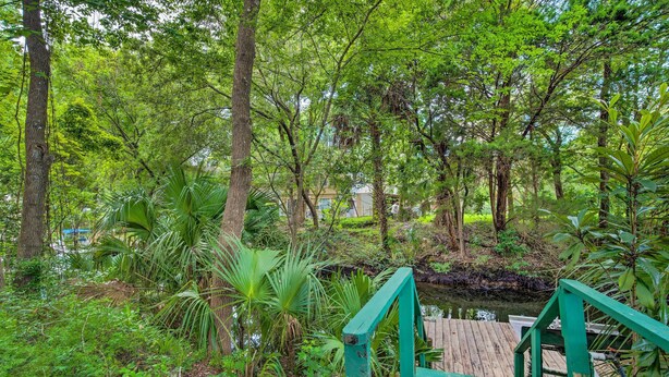 A wooden deck with a green railing overlooking a water body surrounded by dense greenery and trees. - Waterfront Inglis Getaway w/ Dock: 5 Mi to Gulf (Inglis)